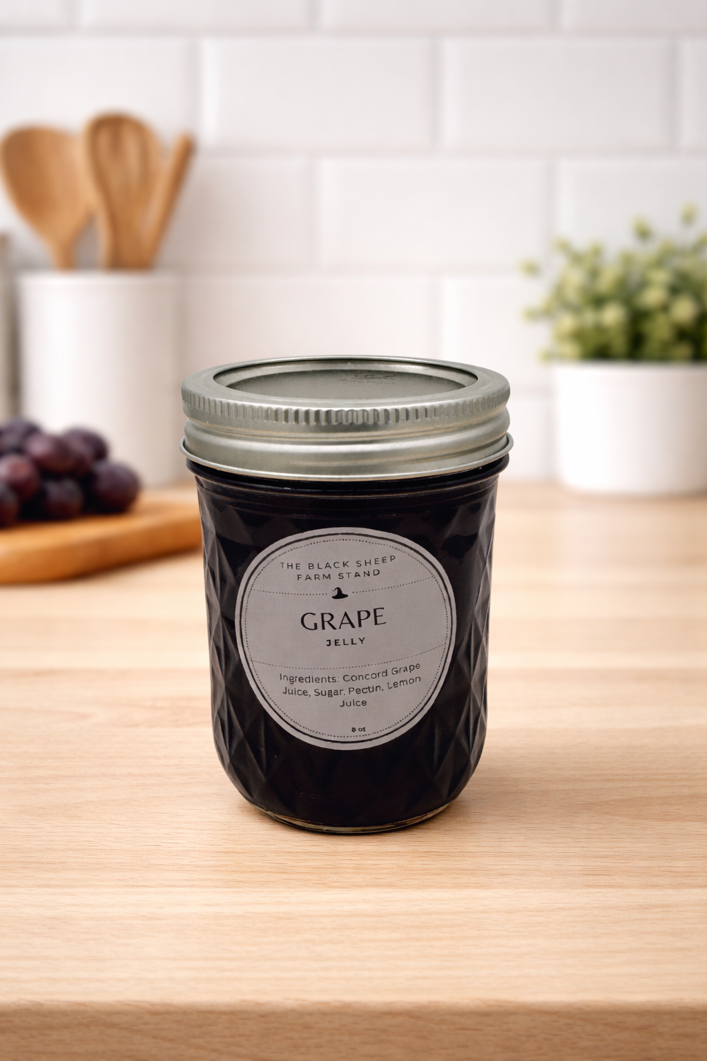 Jar of grape jelly on a wooden table with a kitchen background
