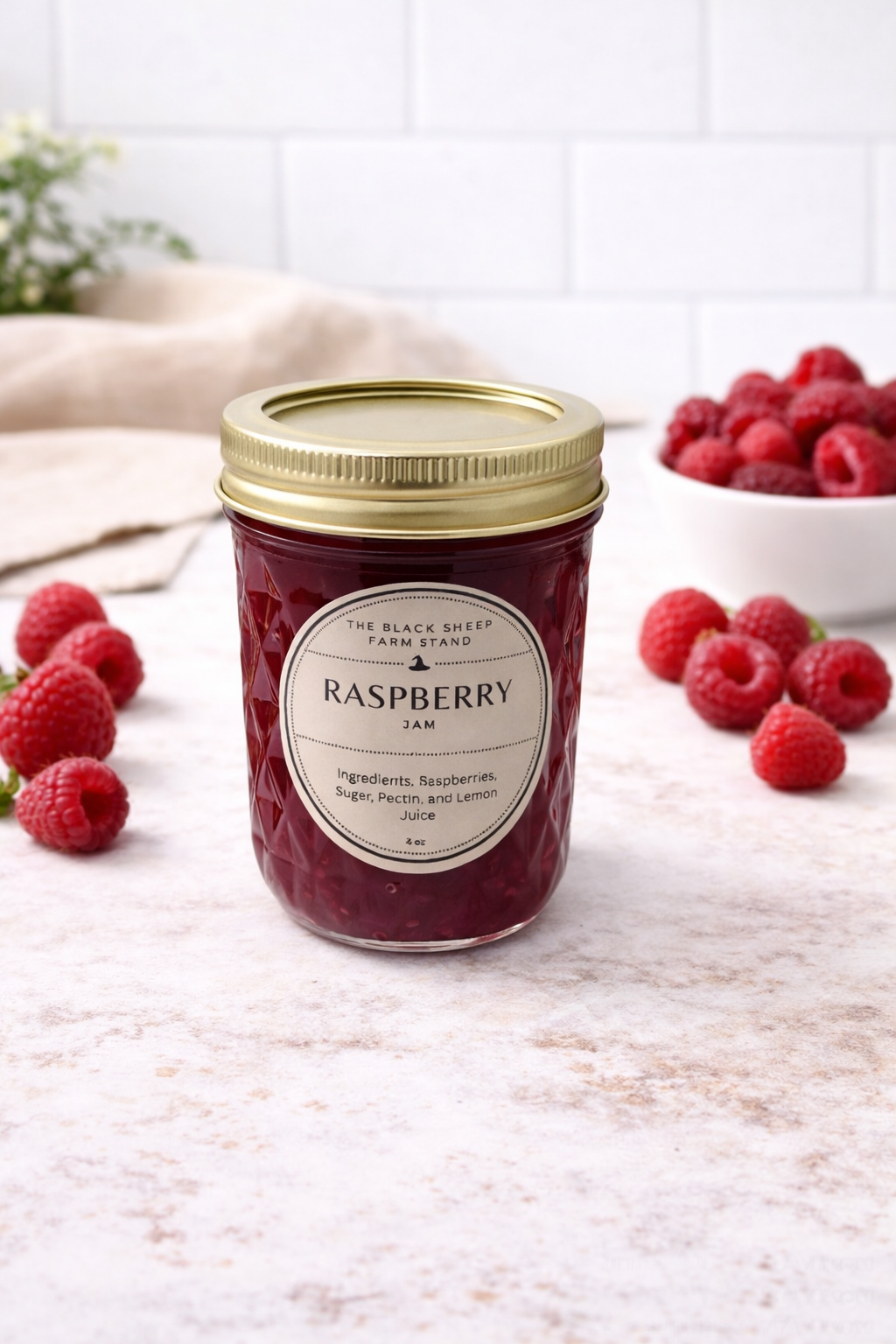 Jar of raspberry jam with a gold lid on a wooden surface, surrounded by fresh raspberries.