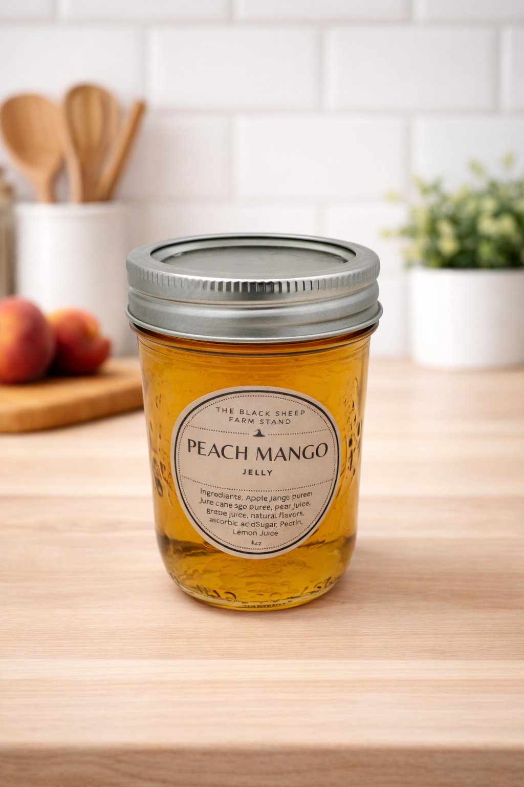 Jar of peach mango jelly on a wooden surface with a kitchen background