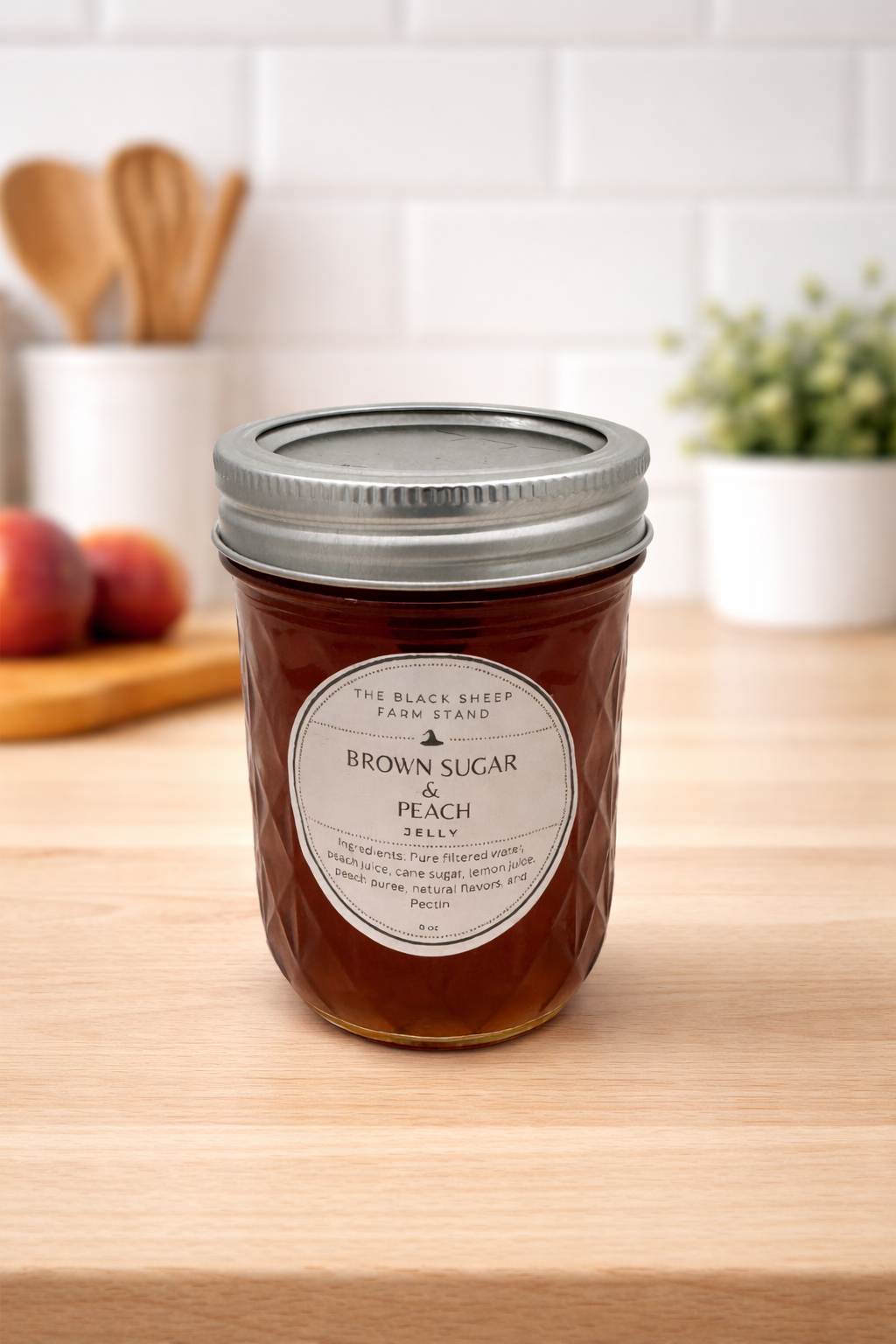 Jar of Brown Sugar Peach Jelly on a wooden surface with a kitchen background