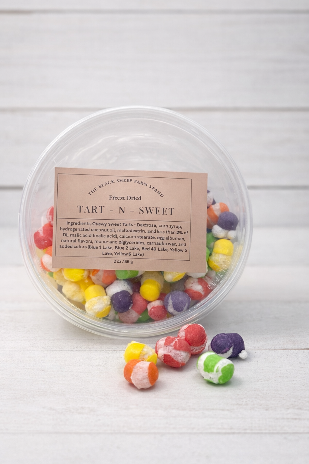 Container of colorful gummy candies with a label on a white background