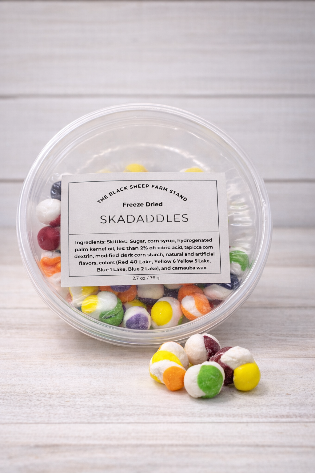 Container of freeze-dried skadaddles with a label on a wooden surface