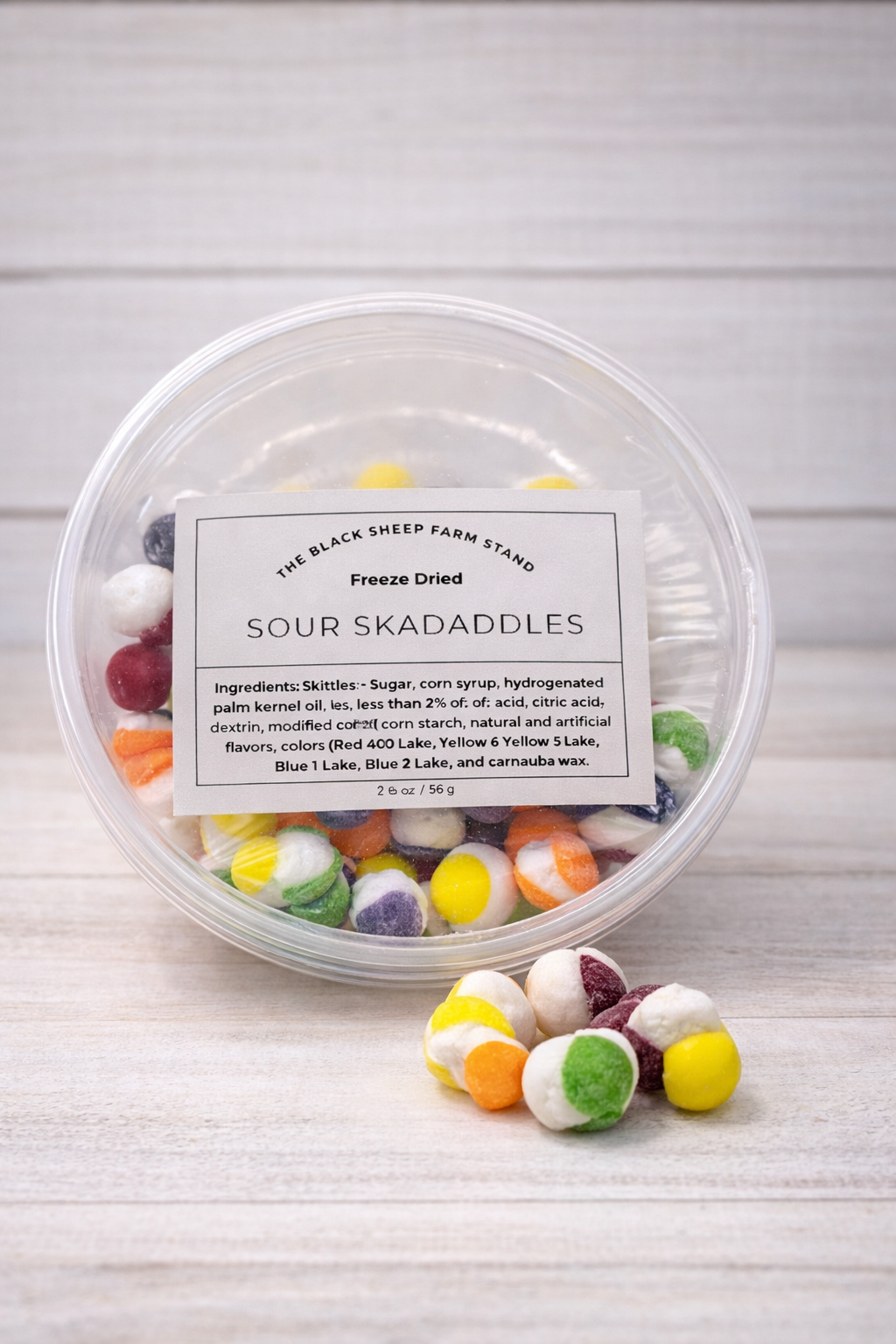 Container of freeze-dried Sour Skadaddles with a label on a wooden surface