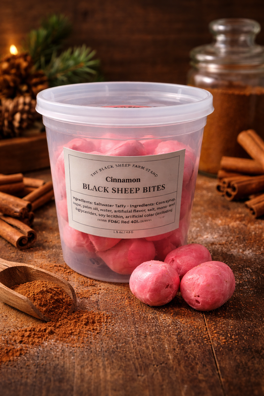 Container of freeze dried Cinnamon saltwater tafft on a wooden countertop with cinnamon sticks and a jar in the background.